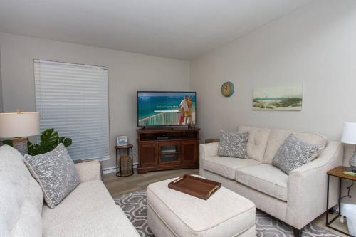 a living room with two couches and a flat screen tv at Cathy and Jim's Florida Beach House in Fort Walton Beach