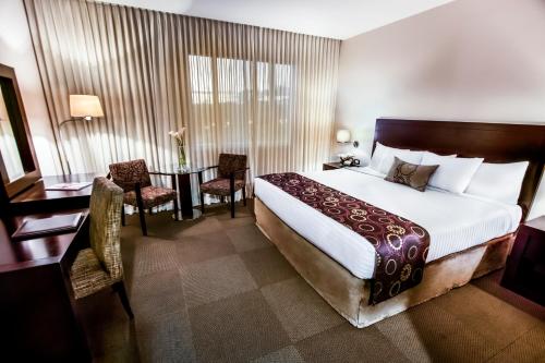 um quarto de hotel com uma cama, uma mesa e cadeiras em Lidotel Barquisimeto em Barquisimito