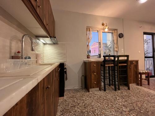 a kitchen with a sink and a counter with stools at Traditional Corfiot House in Perivólion