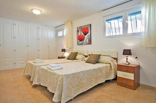 1 dormitorio con 2 camas y 2 ventanas en Villa Calalga - PlusHolidays, en Calpe