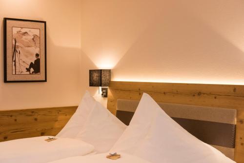 a room with two beds and a picture on the wall at Hotel Brunnenhof in Neustift im Stubaital