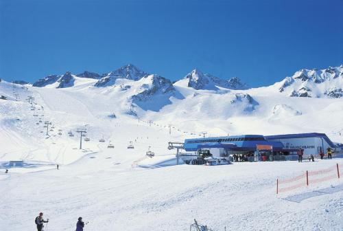 a ski lodge on a snowy mountain with skiers at Hotel Brunnenhof in Neustift im Stubaital