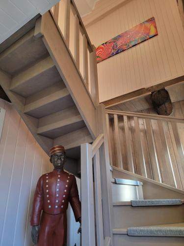 a dollhouse staircase with a statue of a man standing in the middle at Chambre D´hôtes Léonie & Restaurant in Druillat