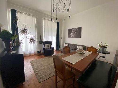a living room with a wooden table and a dining room at Casa do Mocho II in Lisbon