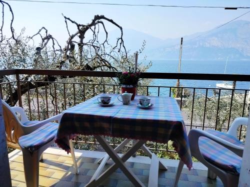 a table and chairs on a balcony with a view of the ocean at Lorena house in Brenzone sul Garda