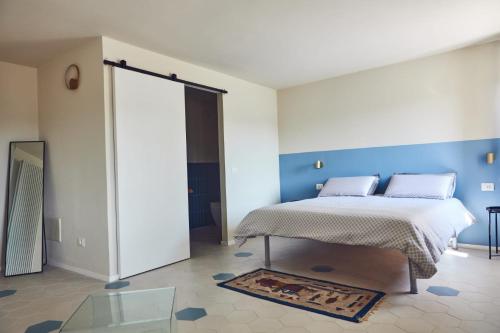 - une chambre avec un lit et un mur bleu dans l'établissement Cascina cortese, à Vigliano d'Asti