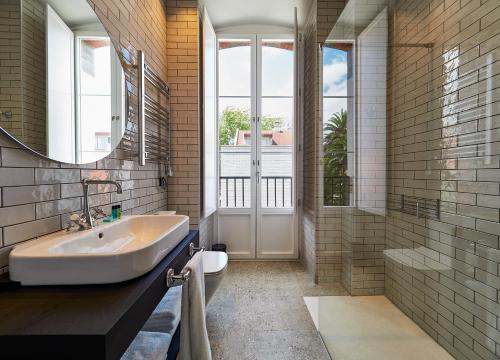 a bathroom with a sink and a tub and a window at Apartamentos Salinas 18 in Salinas