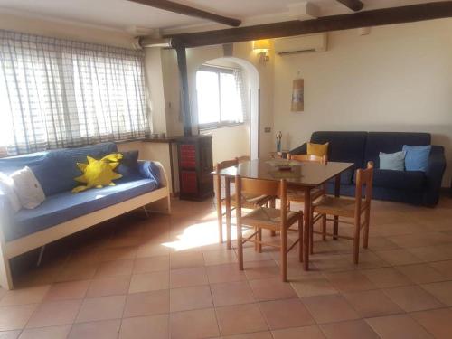 uma sala de estar com uma mesa e um sofá azul em mini appartamenti baciati dal sole em Ischia
