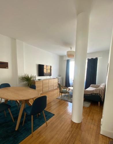 un salon avec une table et une chambre dans l'établissement Le Petit Paris, au Havre