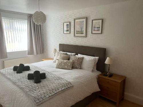 Un dormitorio con una cama grande con dos sombreros. en Luxury Super King Bed, en Stratford-upon-Avon