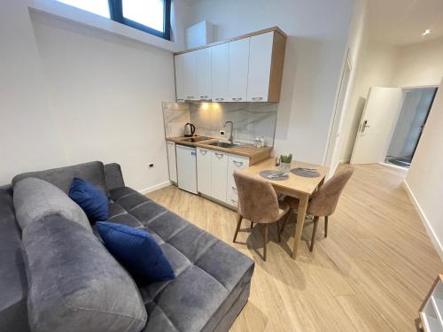 a living room with a gray couch and a table at Arial Trinity Suites in Vlorë