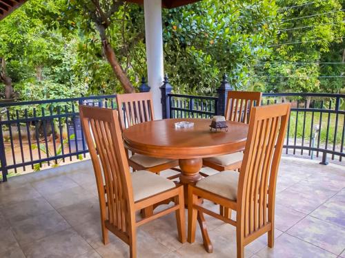 a wooden table and chairs on a patio at Marathona Tourist Resort - Anuradhapura in Anuradhapura