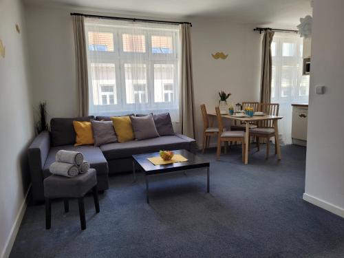 Little Tom Apartments في براغ: غرفة معيشة مع أريكة وطاولة