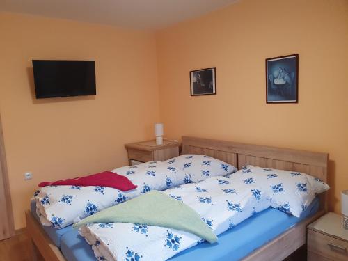 Schlafzimmer mit einem Bett mit blauen und weißen Kissen in der Unterkunft Pension Zelený strom in Mikulov