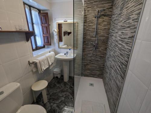 a bathroom with a sink toilet and a shower at Posada Revolgo in Santillana del Mar
