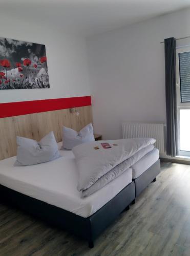 a bedroom with two beds with white pillows at Hotel Hohenloher Tor in Bretzfeld