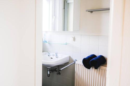 La salle de bains est pourvue d'un lavabo et d'un miroir. dans l'établissement holiday vibes! penthouse-studio near beach, à Ostende