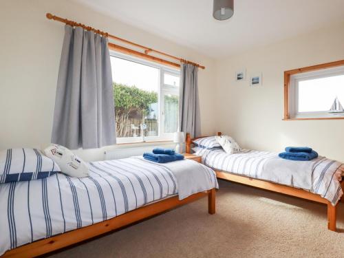 two beds in a room with a window at Brookfield in Bude