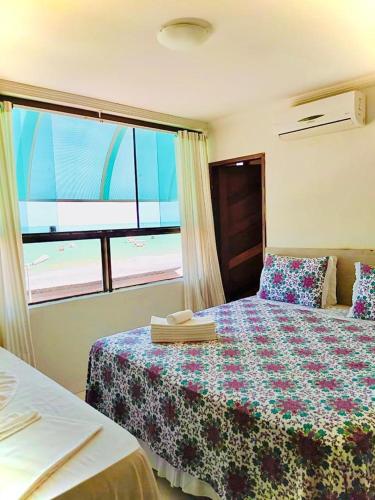 1 dormitorio con 1 cama y vistas a la playa en Pousada Nacional Orla, en Maragogi