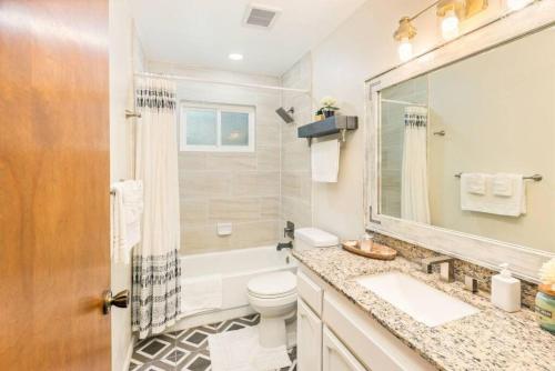 a bathroom with a sink and a toilet and a mirror at Bohemian Chic Cottage near Yosemite in Oakhurst