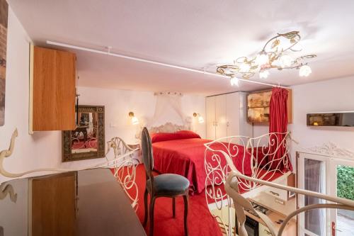a bedroom with a red bed and a chair at MERLO 1 free park & wifi in Pisa