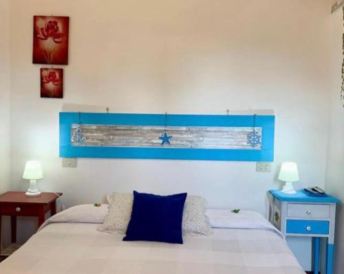 een slaapkamer met een bed met een blauw hoofdeinde bij "IL CASALE DEI GIRASOLI" Country House in Capalbio in Capalbio