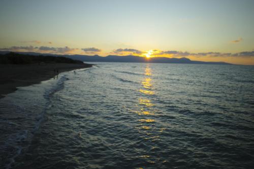 a sunset over a body of water with a beach at C & A Hotel Apartments in Polis Chrysochous