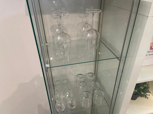 a glass display case with wine glasses in it at [Pvt Terrace] Connected To Duomo in Sesto San Giovanni
