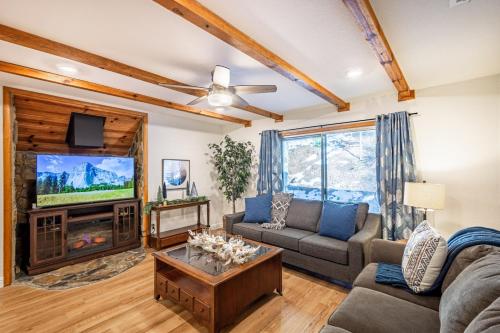 - un salon avec un canapé et une télévision dans l'établissement Sugarpine Trailhead Lodge at Lewis Creek Upper Trailhead just 7 miles from Yosemite, à Oakhurst