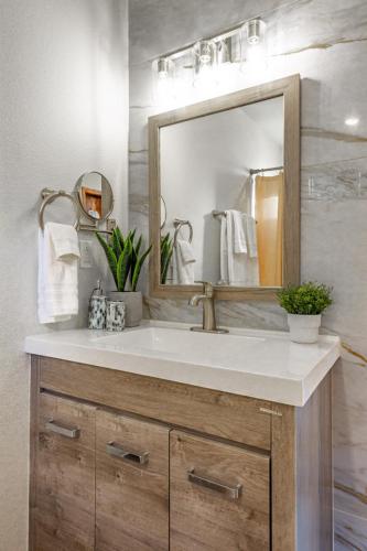 a bathroom with a sink and a mirror at Sugarpine Trailhead Lodge at Lewis Creek Upper Trailhead just 7 miles from Yosemite in Oakhurst
