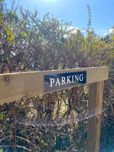 a sign that says parking on a wooden post at Wee Silverburn in Whiting Bay