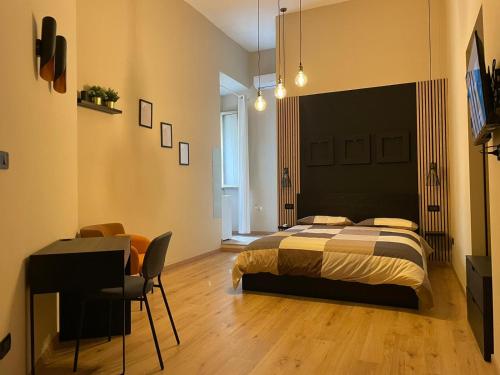 - une chambre avec un lit, un bureau et une table dans l'établissement SCIÒ SCIÒ HOUSE casa contro il malocchio, à Naples