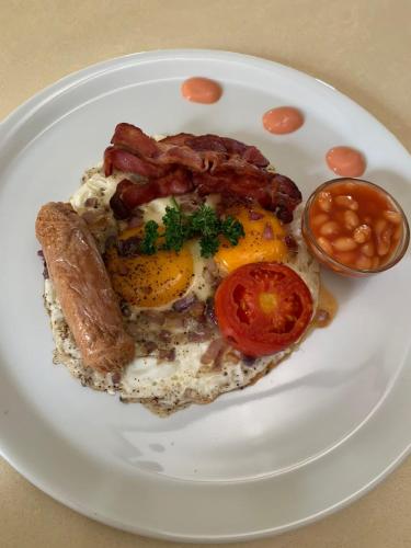 a plate of breakfast food with eggs bacon and beans at Savannah Suites in Kampala