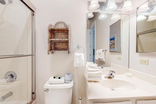 ein Badezimmer mit einem Waschbecken, einem WC und einem Spiegel in der Unterkunft Spanish Key 708 in Perdido Key