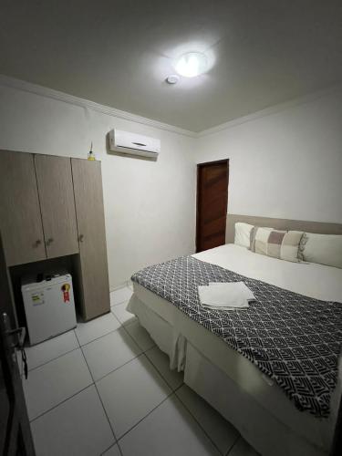 Un dormitorio con una cama con una toalla. en Pousada Nacional Orla, en Maragogi