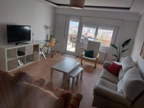 un soggiorno con divano e tavolo di Ático con terraza a Vigo