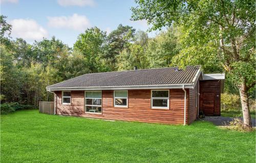 a log cabin in a yard with green grass at 4 Bedroom Amazing Home In Hasle in Hasle