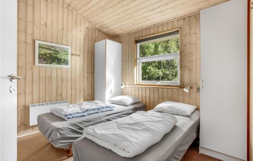two beds in a room with wooden walls at 4 Bedroom Amazing Home In Hasle in Hasle