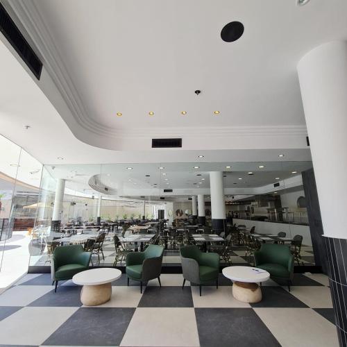 a restaurant with tables and chairs in a building at Jacob Eilat in Eilat