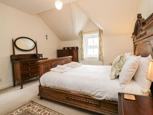 a bedroom with a large bed and a mirror at Flat 1 Kentholme in Grange Over Sands