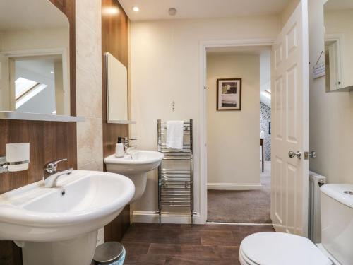 a bathroom with two sinks and a toilet at Flat 1 Kentholme in Grange Over Sands