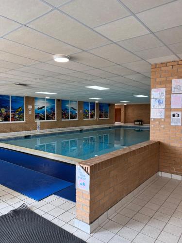 a large swimming pool in a building at Cosy country style static holiday home in Aberystwyth