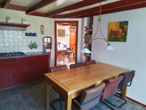 una cucina e una sala da pranzo con tavolo e sedie in legno di Vakantiewoning 't Veurhuus a Bergentheim