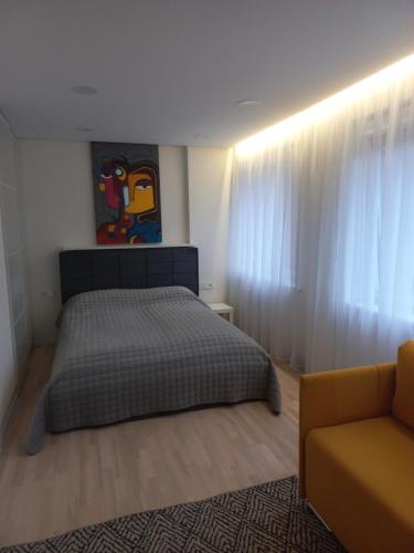 um quarto com uma cama e um sofá em Vėtrungė center apartment em Klaipėda