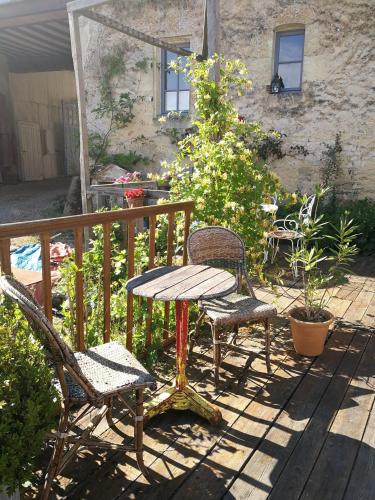 un patio con mesa y sillas en una terraza en LA GUINGUETTE DE BELLEME en Bellême