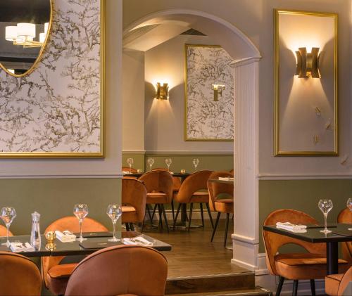 a dining room with tables and chairs and a mirror at Osborne Hotel in Newcastle upon Tyne