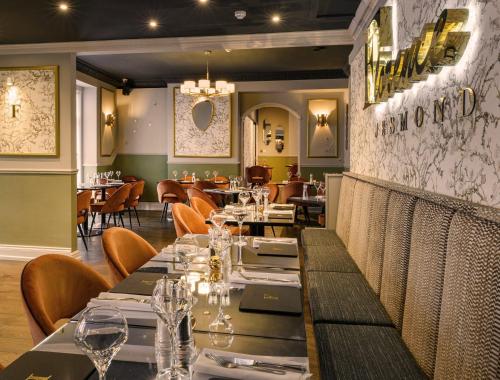 a dining room with tables and chairs in a restaurant at Osborne Hotel in Newcastle upon Tyne