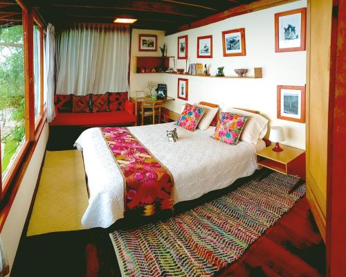 1 dormitorio con cama, mesa y ventana en Finca Petrona, en Mindo