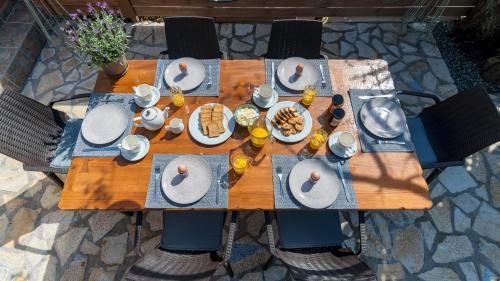 a wooden table with plates of food on it at Star Jasmine House Acharavi in Litherés