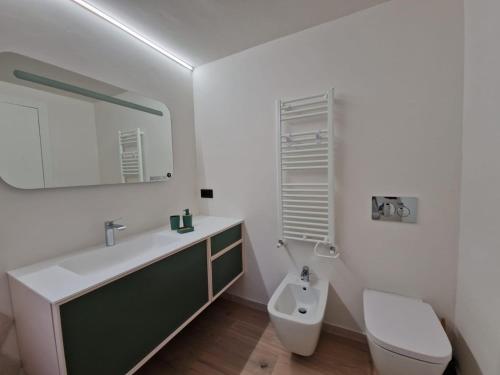 a bathroom with a sink and a toilet and a mirror at REGINA Loft in Ospedaletti